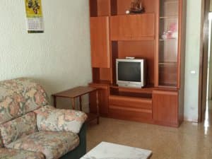 Salón con sillón y mueble de televisión