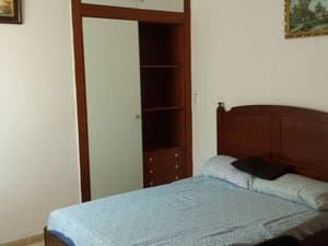 Dormitorio con armario empotrado y cabecero de madera
