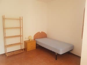 Dormitorio con cama individual y estantería
