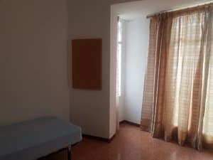 Dormitorio con cama y ventana con cortinas