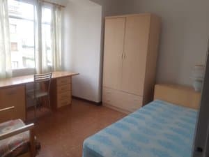Dormitorio con escritorio y armario claro