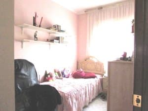 Dormitorio con cama, estantes y ventana