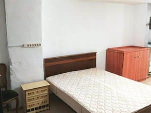 Zona de dormitorio con cama y cómoda
