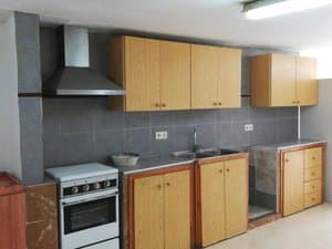 Cocina con muebles de madera, fregadero doble y campana