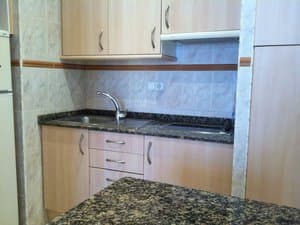 Cocina con encimera de granito y fregadero