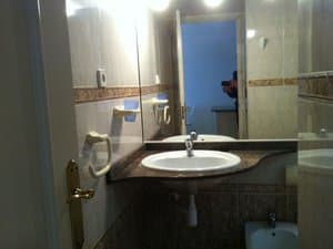 Baño con lavabo sobre encimera y espejo