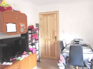 Comedor con mueble de televisión y puerta de madera