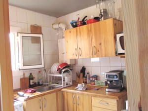 Cocina con muebles de madera, microondas y cafetera