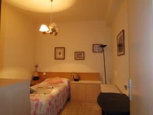 Dormitorio con cama individual y cuadros