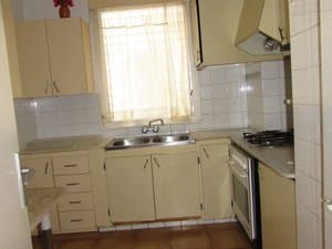 Cocina con placa de gas, horno y fregadero doble