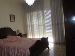 Dormitorio con cama de matrimonio y ventanal