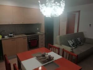Salón comedor con mesa, sofá y cocina americana