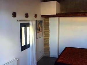 Dormitorio con ventana, cortina y radiador