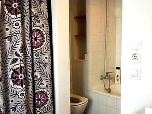 Baño con bañera, cortina e inodoro