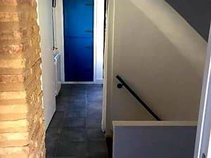 Pasillo con escalera y pared de ladrillo
