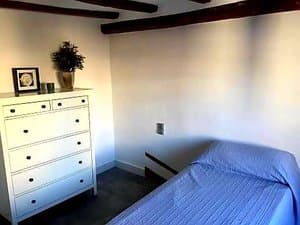 Dormitorio con cama y cómoda blanca
