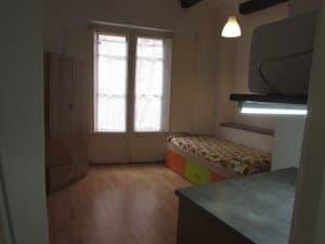 Estudio con cama, armario y puerta balconera