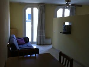 Salón con ventilador de techo y puertas balconeras