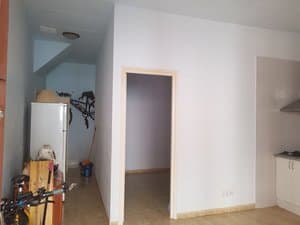 Entrada con frigorífico y paso al dormitorio