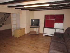 Salón con vigas de madera, sofá y mueble