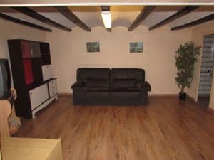 Salón amplio con sofá y suelo de tarima