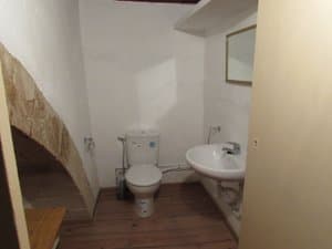 Aseo con inodoro y lavabo bajo un arco