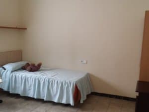 Dormitorio con cama individual y estante