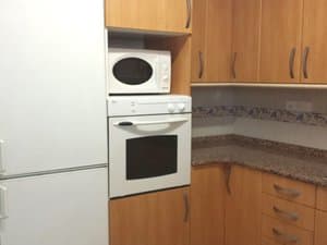 Cocina con frigorífico, horno y microondas