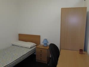 Dormitorio con cama individual y escritorio