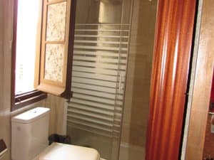 Baño con ducha de mampara e inodoro