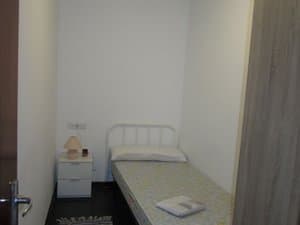 Dormitorio con cama individual y mesita