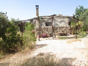 Casa con pérgola de ramas y chimenea