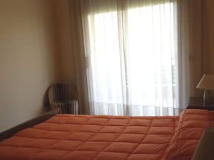 Dormitorio con cama de matrimonio y puerta balconera