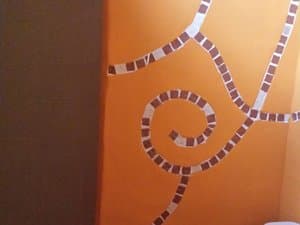 Detalle de mosaico en una pared naranja