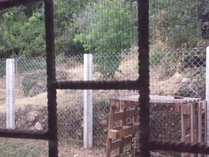 Vista del terreno cercado desde una ventana con reja