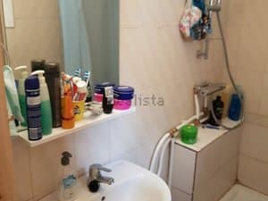 Baño con lavabo, espejo y estante