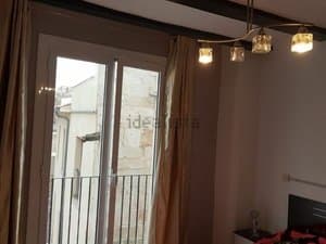 Dormitorio con puerta balconera y lámpara de techo