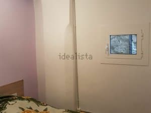 Dormitorio con cama y ventana interior