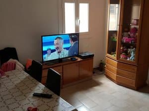 Comedor con mesa, televisor y vitrina