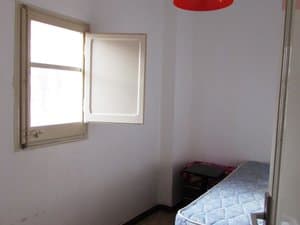 Dormitorio con cama individual y ventana