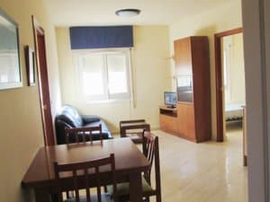 Comedor con mesa, sofá y mueble de televisión