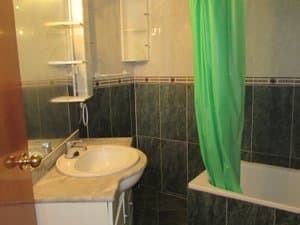 Baño con lavabo sobre mueble y bañera