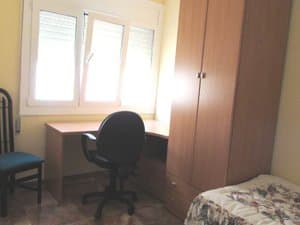 Dormitorio con escritorio junto a la ventana