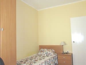 Dormitorio con cama individual y mesita