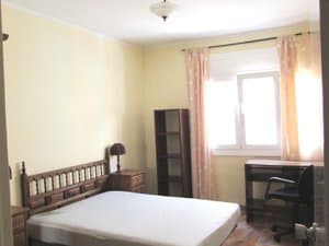 Dormitorio con cama, estantería y escritorio