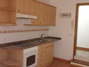 Cocina con muebles de madera, horno y campana