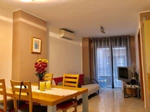 Salón comedor con mesa, aire acondicionado y puerta balconera