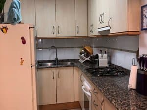 Cocina con placa de gas, fregadero y frigorífico