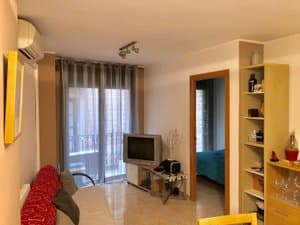 Salón con sofá cama y televisor