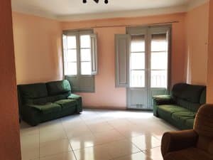 Salón con sofás verdes y puertas balconeras